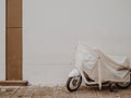 Scooter parking on the side of the street with plastic sheet covering. Royalty Free Stock Photo