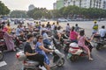 Scooters drivers wait for green light on an intersection in downtown Guilin at sunrise.