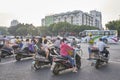 Scooters drivers wait for green light on an intersection in downtown Guilin at sunrise.