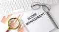 SCOPE MANAGEMENT text written on a notebook with keyboard, chart,and glasses Royalty Free Stock Photo