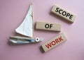 Scope of Work symbol. Concept words Scope of Work on wooden blocks. Beautiful pink background with boat. Business and Scope of