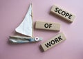 Scope of Work symbol. Concept words Scope of Work on wooden blocks. Beautiful pink background with boat. Business and Scope of