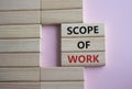 Scope of Work symbol. Concept words Scope of Work on wooden blocks. Beautiful pink background. Business and Scope of Work concept