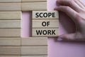 Scope of Work symbol. Concept words Scope of Work on wooden blocks. Businessman hand. Beautiful pink background. Business and