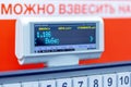 Scoreboard electronic scales at the grocery store. Text in Russian: weight, price, cost