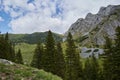 Scorota sheepfold in Retezat mountain with peak forest blue sky Royalty Free Stock Photo