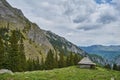 Scorota sheepfold in Retezat mountain with peak forest blue sky Royalty Free Stock Photo