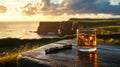 Scotch and cigars on rustic table with scotland s coastal heritage and sunlit cliffs in background Royalty Free Stock Photo