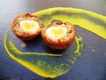 Scotch Egg halved with Yellow Mustard on Slate Plate Royalty Free Stock Photo