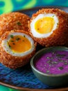 Scotch egg with sauce on a vibrant blue plate Royalty Free Stock Photo