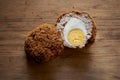 Scotch Egg Sliced in Half on a Wooden Background Royalty Free Stock Photo