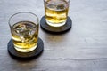 Scotch - two glasses with ice - on grey stone background copy space