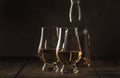 Scotch Whiskey without ice in glasses and bottle, rustic wood background, copy space