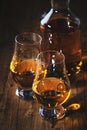 Scotch Whiskey without ice in glasses and bottle, rustic wood background, copy space