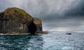 Rain showers and Staffa Island off the coast of Scotland.