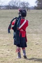 Scots guards piper on field with bagpipes