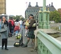 A Scottish Bagpipe Player on a Busy Westminster bridge in London