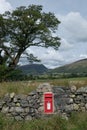 Scottish Boarders UK 10/09/2017 Red Post Box in a dry stone wall mountains tree