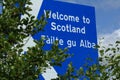 Scottish border sign, view through trees. Royalty Free Stock Photo