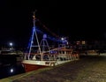 The Scottish Fishing Boat, the Sparkling Rose moored in Arbroath Harbour with strings of multicoloured lights between its Masts. Royalty Free Stock Photo
