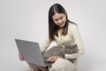 Scottish fold lovely cats lying on young woman hand while working with laptop computer on white studio background