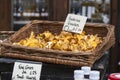 girolles in a wicker box that hangs on the wall, for sale on the market
