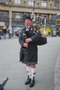 Scottish highlander wearing kilt playing bagpipes
