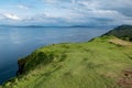 Scottish landscape with hills and shoreline near Staffin at Isle of Skye with green pastures for sheep