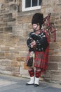 Scottish piper man dressing in Scottish traditional tartan kilt playing a bagpiper at Royal Mile in Edinburgh, Scotland, UK Royalty Free Stock Photo