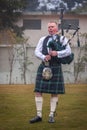 Scottish piper from Scotland in traditional outfit with tartan kilt playing bagpipe Royalty Free Stock Photo
