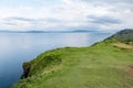 Scottish shoreline with green hills near Staffin city at Isle of Skye with green pastures