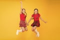 Scottish style. Cheerful friends schoolgirls jumping yellow background. Celebrate holiday. Scottish holiday. Join