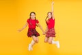 Scottish style. Cheerful friends schoolgirls jumping yellow background. Celebrate holiday. Scottish holiday. Join