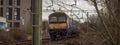 Scottish train in Glasgow, commuter train driving from glasgow central station towards west. Train in a curve between bare bushes