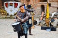 A Scottish warrior, soldier, musician beats the drum on the square of a medieval old castle. Nesvizh, Belarus, October 12, 2018