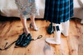 Scottish wedding preparations. Man in a kilt stands next to woman in a skirt with high-heeled shoes. There are shoes
