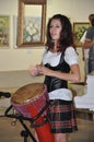 Scottish young woman playing a drum, sing