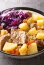 Scouse is a slow lamb stew with potatoes, turnips, onions and carrots close-up in a plate. Vertical