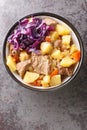 Scouse is a slow lamb stew with potatoes, turnips, onions and carrots close-up in a plate. Vertical top view
