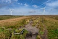 Scout Moor wind farm electric energy producing turbines with footpath leading across the open hillside Royalty Free Stock Photo