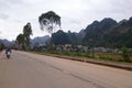 Scouter driver, trees on the side of the road, mountains in the background