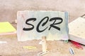 scr text on a piece of paper on the table with a clothespin clamped Royalty Free Stock Photo