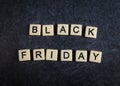 Scrabble letter tiles on black slate background spelling Black Friday