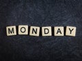 Scrabble letter tiles on black slate background spelling Monday Royalty Free Stock Photo