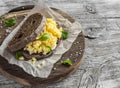 Scramble egg sandwich on rustic wooden background.