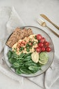 Scramble eggs with cherry tomatoes, fresh spinach leaves, avocado and crispbreads