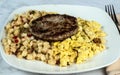 scramble eggs and hash browns top with sausage patty