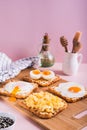 Scrambled egg, poached egg, fried egg, boiled egg on toast on a board vertical view