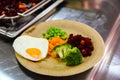 Scrambled egg, vinegret, broccoli, peas and carrot on a cardboard plate on the table Royalty Free Stock Photo