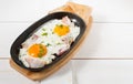 Scrambled eggs with bacon and fresh herbs fried in a pan. Served with bread toast Royalty Free Stock Photo